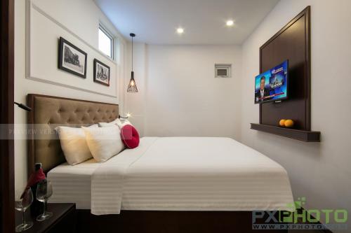 a bedroom with a bed with white sheets and pillows at Victory Legend Hotel - In Hanoi Central in Hanoi