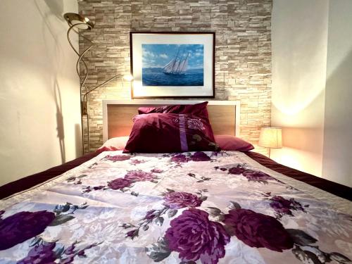 a bedroom with a bed with purple flowers on it at The Standalone - 4 Bedroom Home with Garden by Wild in London