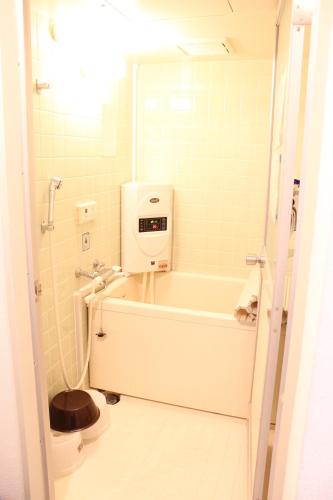 a bathroom with a bath tub and a toilet at 大曽根駅から徒歩5分人工温泉が24時間楽しめてナゴヤドームまで徒歩で行く事が出来ます in Yadachō