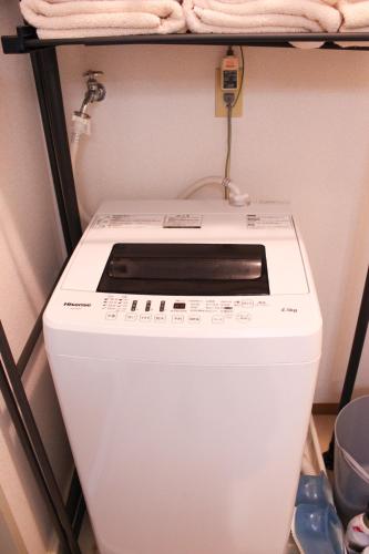 a washing machine is sitting on a shelf at 大曽根駅から徒歩5分人工温泉が24時間楽しめてナゴヤドームまで徒歩で行く事が出来ます in Yadachō