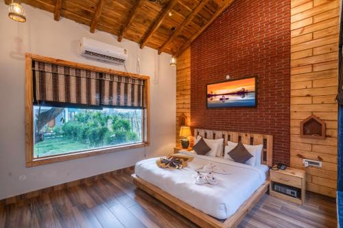 Schlafzimmer mit einem großen Bett und einem Fenster in der Unterkunft The Destin Ekaant By 3Tree Group in Belparāo