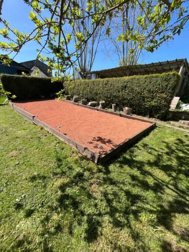 a garden with a plot of dirt in the grass at Maison Normandie in Fresles