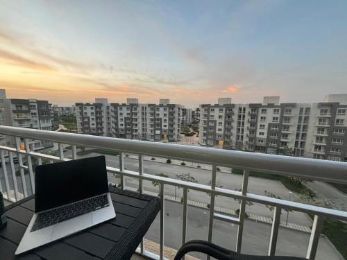 a laptop computer sitting on a table on a balcony at Luxury Inn: 2BR Prime location in Madinaty B12 in Madinaty