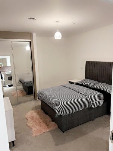sypialnia z łóżkiem i lustrem w obiekcie Gabs place w mieście Stifford