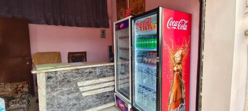 einem Coca-Cola-Kühlschrank neben einer Theke in der Unterkunft Maa kaushalya Guest House in Ayodhya in Ayodhya
