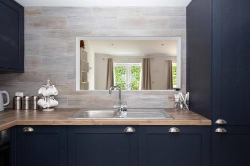 a bathroom with a sink and a mirror at York Cottage in Cirencester