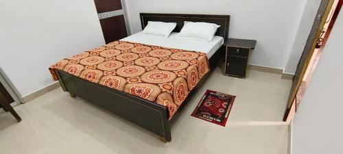 ein Schlafzimmer mit einem großen Bett mit einer roten Decke in der Unterkunft Maa kaushalya Guest House in Ayodhya in Ayodhya