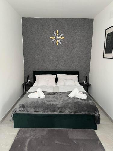 a bedroom with a large bed with a clock on the wall at Shubu GARDEN Vendégházak in Szilvásvárad