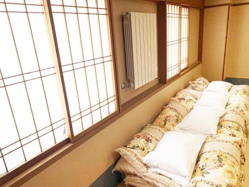 ein Sofa in einem Zimmer mit zwei großen Fenstern in der Unterkunft Hashima - Hotel - Vacation STAY 52732v in Hashima