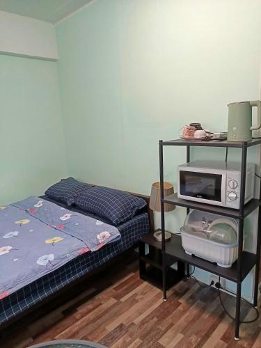 a bedroom with a bed and a microwave on a shelf at SV. HOUSE in Jomtien Beach