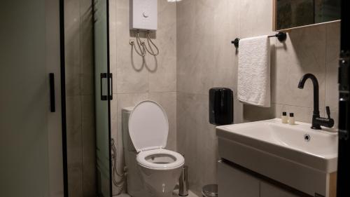a bathroom with a toilet and a sink and a phone at Şahmaran Bungalov in Ardeşen