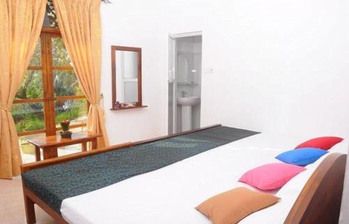 uma cama grande num quarto com uma janela em The Colombo Village em Colombo