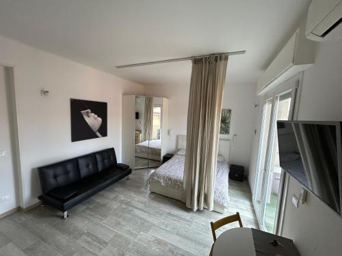 sypialnia z kanapą, łóżkiem i telewizorem w obiekcie Stayinbologna 2 w Bolonii