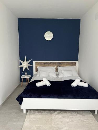 a bedroom with a large bed with a blue wall at Shubu GARDEN Vendégházak in Szilvásvárad