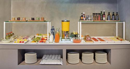 a buffet with plates and food on a table at NH Collection Andorra Palomé in La Massana