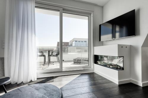 a living room with a fireplace and a large window at Haus Noena in Norderney