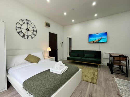 1 dormitorio con 1 cama y reloj en la pared en Beautiful Studio Flat in Hackney next to Overground Station en Londres