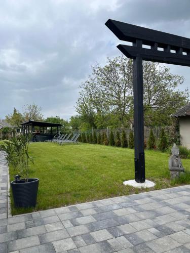 a black pole in a yard with a grass field at Shubu GARDEN Vendégházak in Szilvásvárad