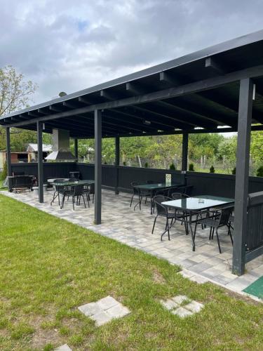 a pavilion with tables and benches in a park at Shubu GARDEN Vendégházak in Szilvásvárad