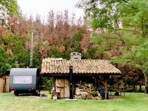 a trailer is parked next to a shed at INTO THE WILD - Nos 5 logements "Atypiques" in Belin-Beliet