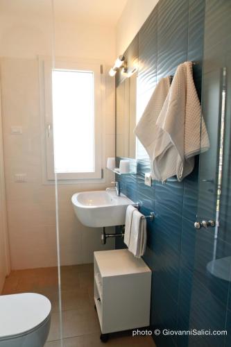 a bathroom with a sink and a toilet and a mirror at Garden Rooms 2 in Menaggio