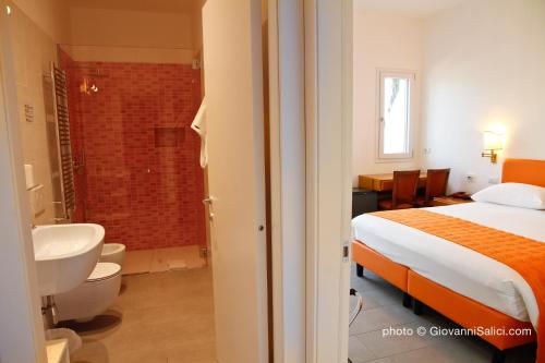 ein Schlafzimmer mit einem Bett und ein Badezimmer mit einer Dusche in der Unterkunft Garden Rooms 2 in Menaggio