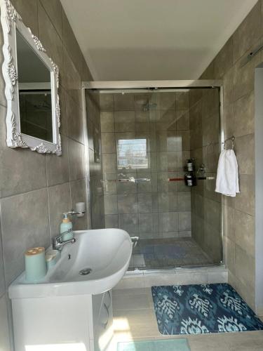 La salle de bains est pourvue d'une douche, d'un lavabo et d'une baignoire. dans l'établissement York-R102 Airport Road, à George