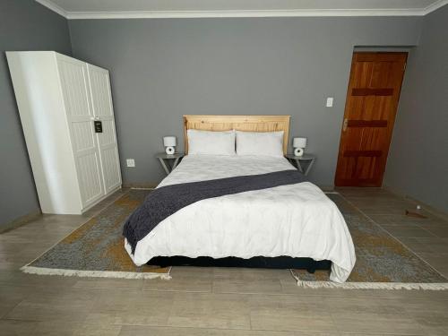 - une chambre avec un grand lit et 2 tables de chevet dans l'établissement York-R102 Airport Road, à George