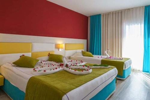 two beds in a hotel room with red walls at Side Win Hotel & Spa - All Inclusive in Side