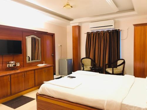 Habitación de hotel con cama y TV en Naveed Residency en Anantapur