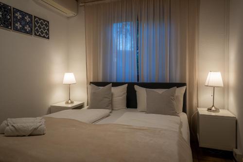 Un dormitorio con una gran cama blanca con dos lámparas. en EPA Apartment - España style, en Rust