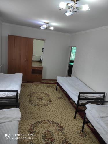 a bedroom with two beds and a rug at Your House in Karakol