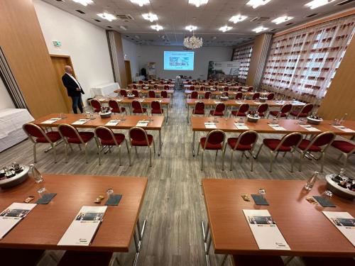 a large room with tables and chairs and a man at Hotel Empfinger Hof, Sure Hotel Collection by Best Western in Empfingen