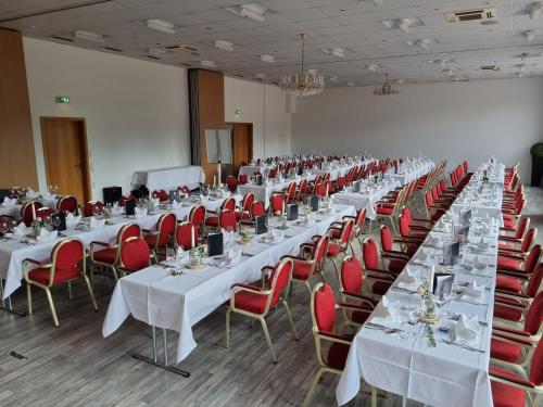 a large room with white tables and red chairs at Hotel Empfinger Hof, Sure Hotel Collection by Best Western in Empfingen