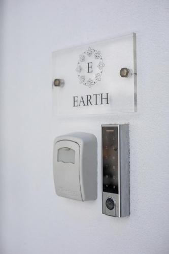 a white wall with a lightswitch and a card with the word earth at Bliss Luxury Suites in Lindos