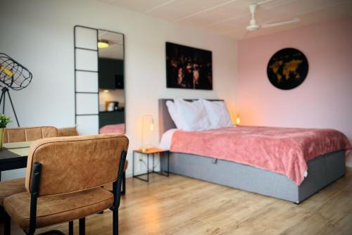 a bedroom with a bed and a desk and a chair at Flamingo Studio's Zeeland in Schoondijke