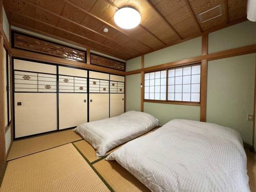 2 Betten in einem Zimmer mit Schließfächern in der Unterkunft 百代家 飛騨高山 若達町 in Takayama