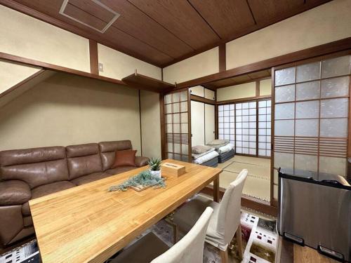 ein Wohnzimmer mit einem Sofa und einem Holztisch in der Unterkunft 百代家 飛騨高山 若達町 in Takayama