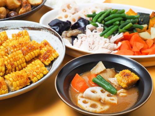 a table topped with bowls of food with corn and vegetables at APA Hotel Sapporo Susukino Ekimae in Sapporo