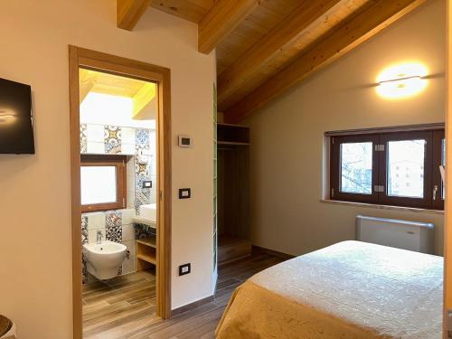 um quarto com uma cama e uma casa de banho com um lavatório em LorichiAmo B&b em Lorica