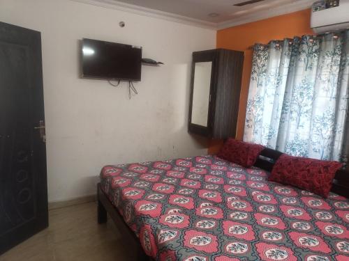 a bedroom with a bed and a flat screen tv at Sapthagiri lodge in Visakhapatnam