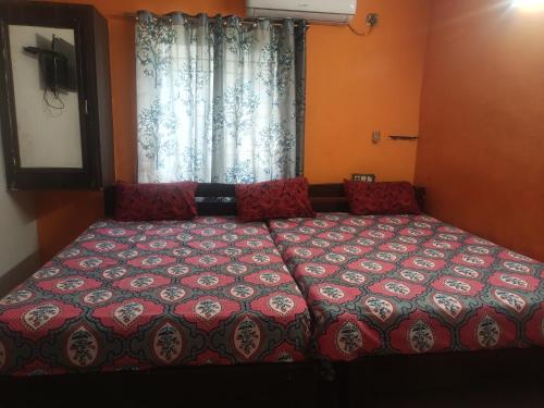 a bedroom with a bed with a red comforter and a window at Sapthagiri lodge in Visakhapatnam