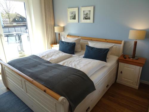 a bedroom with a large bed with blue pillows at Gode Wind Quartiere 5 in Dahme