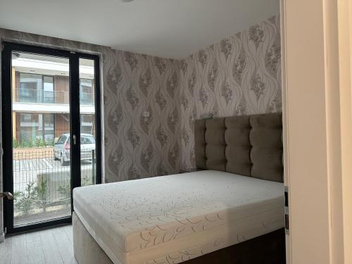 a bedroom with a bed and a sliding glass door at Сарафово Лукс Гарден Първа Линия in Burgas City