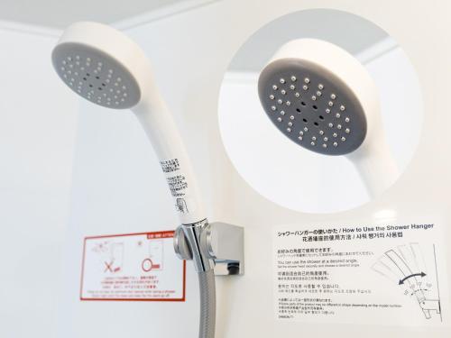 a shower with a shower head on a wall at APA Hotel Sapporo Susukino Ekimae in Sapporo