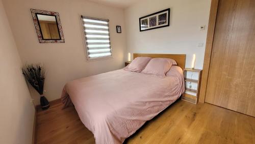1 dormitorio con cama con sábanas rosas y ventana en Appartement Dilece, en Pouzac