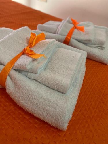 a group of folded towels with an orange ribbon at Casa Nando Relax e comfort home in Marina di Ascea