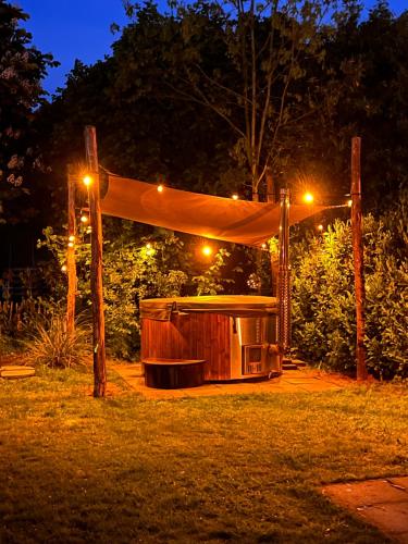 a gazebo at night with lights on it at Vrijstaande 6 persoons Bungalow hottub en pizzaoven op vakantiepark in Ewijk