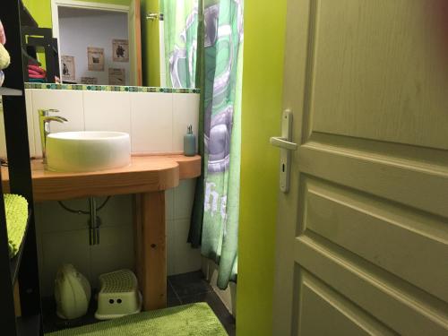 a bathroom with a sink and a mirror and a door at Au Rendez-Vous des Sorciers II in Aniane