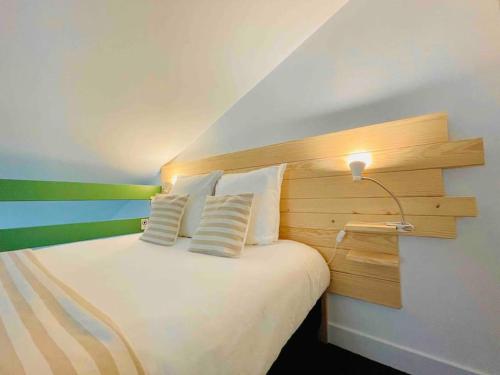 - une chambre avec un lit doté d'une tête de lit et d'une lampe dans l'établissement 2 apts communiquants cosy insolites coeur de ville, à Angoulême